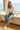 Model sitting comfortably in palm-print pajama pants