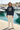 Navy hoodie with cream wide-leg trousers at a marina