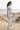 Pale-blue tee and camo leggings along beach dunes