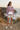 Pink hoodie with ivory shorts at coastal cliffs