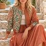 Seated model in the same pose wearing the split-dye bomber