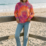 Tie-dye hoodie styled on a beachside boardwalk