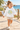 Two-year-old girl in white hoodie on a beach boardwalk