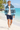 White male model wearing the African Origins blue windbreaker on a Zanzibar-inspired beach