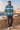 White male model wearing the African Origins blue windbreaker on an Essaouira-inspired shoreline