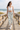 White sports bra and camo leggings on a beach boardwalk