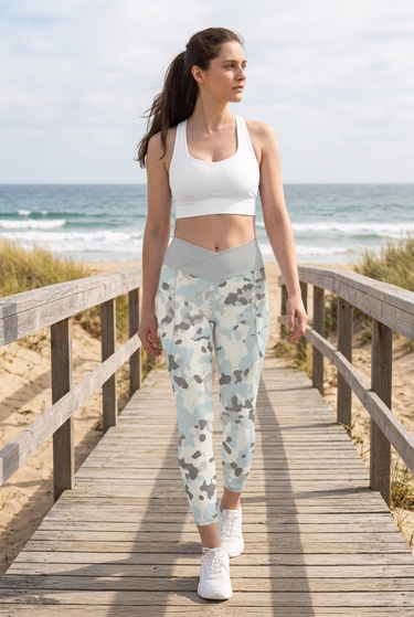 White sports bra and camo leggings on a beach boardwalk